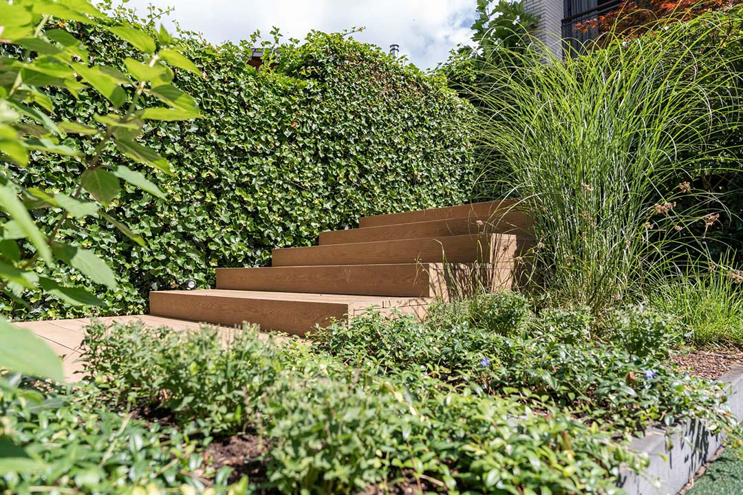 Verhoogde afwerking met planken tussen de groene borders
