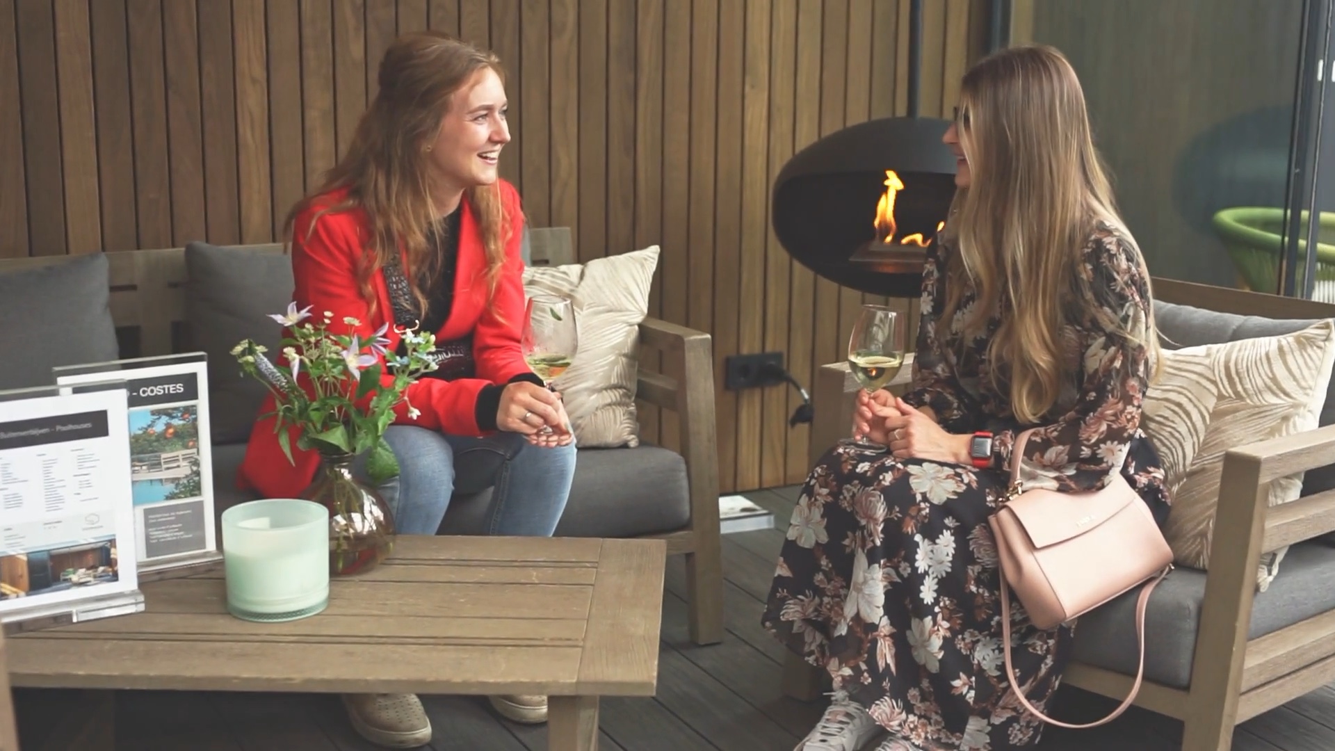 Twee bezoekers in gesprek bij een zithoek en haard in de showroom.