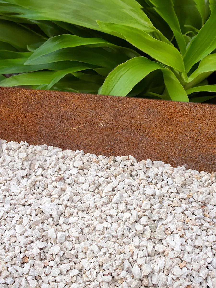 Roestkleurige kantopsluiting tussen licht split en groene beplanting